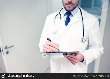 medicine, healthcare, profession and people concept - close up of male doctor with clipboard and stethoscope at hospital. close up of doctor with clipboard at hospital