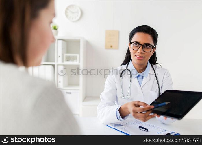medicine, healthcare, technology and people concept - doctor with tablet pc computer and woman patient meeting at hospital. doctor with tablet pc and woman patient at clinic