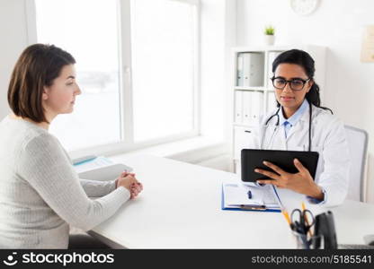 medicine, healthcare, technology and people concept - doctor with tablet pc computer and woman patient meeting at hospital. doctor with tablet pc and woman patient at clinic