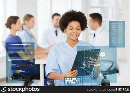 medicine, healthcare, technology and people concept - happy african american female doctor or nurse with clipboard over group of medics at hospital. happy doctor with clipboard at hospital