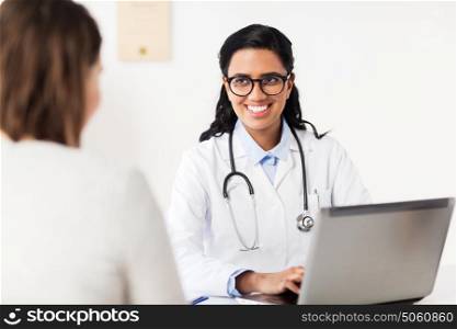 medicine, healthcare, technology and people concept - smiling doctor with laptop computer and woman patient at hospital. doctor with laptop and woman patient at hospital