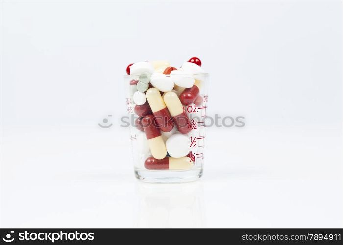 Medicine in glass. Drug capsules in glass. Isolated white background