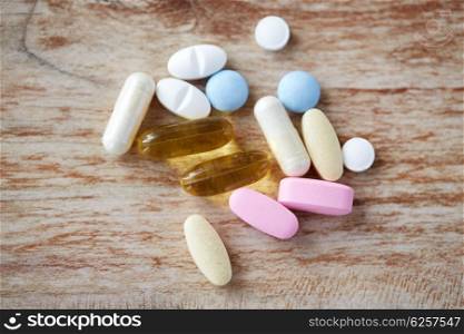 medicine, nutritional supplements and food additives concept - close up of vitamin pills with cod liver oil capsules
