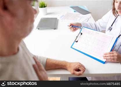 medicine, old age, healthcare, cardiology and people concept - senior man and doctor showing cardiogram on clipboard in medical office at hospital