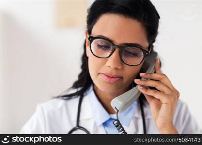 medicine, people and healthcare concept - female doctor in glasses calling on phone at hospital. doctor in glasses calling on phone at hospital. doctor in glasses calling on phone at hospital