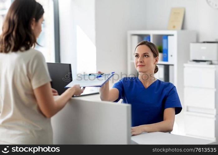 medicine, people and healthcare concept - female doctor or nurse with clipboard and patient at hospital. doctor with clipboard and patient at hospital