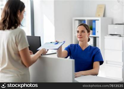 medicine, people and healthcare concept - female doctor or nurse with clipboard and patient at hospital. doctor with clipboard and patient at hospital