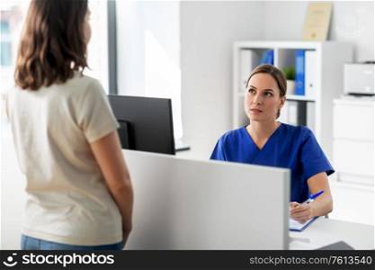 medicine, people and healthcare concept - female doctor or nurse with computer and patient at hospital. doctor with computer and patient at hospital