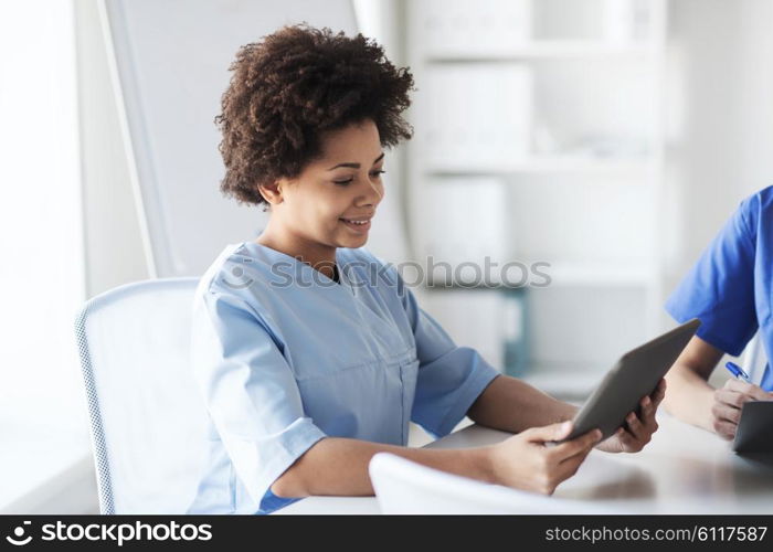 medicine, people and healthcare concept - happy female doctor or nurse with tablet pc computer at hospital