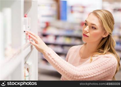 medicine, people and healthcare concept - young woman at. young woman at pharmacy