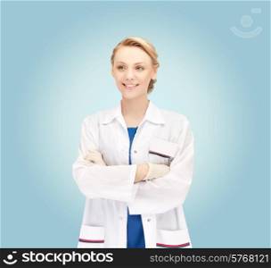 medicine, people, profession and healthcare concept - smiling young female doctor in white coat over blue background