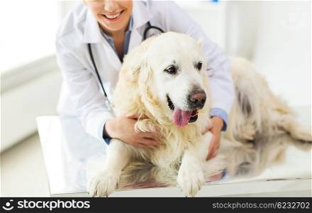 medicine, pet, animals, health care and people concept - close up of happy veterinarian or doctor with golden retriever dog at vet clinic