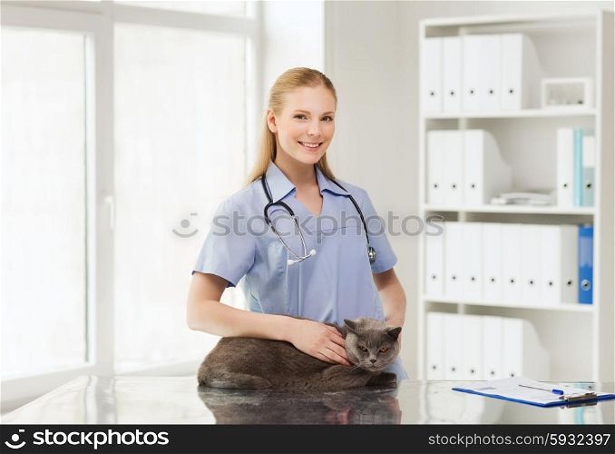 medicine, pet, animals, health care and people concept - happy doctor or veterinarian with stethoscope checking british cat up at vet clinic