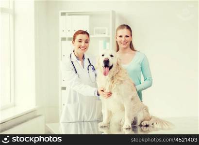 medicine, pet, animals, health care and people concept - happy woman with golden retriever dog and veterinarian doctor at vet clinic