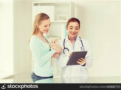 medicine, pet, health care, technology and people concept - happy woman and veterinarian doctor with tablet pc computer checking scottish fold kitten up at vet clinic