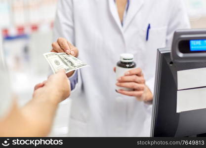 medicine, pharmaceutics, health care and people concept - close up of pharmacist selling drug and taking money at pharmacy. close up of pharmacist selling drug at pharmacy