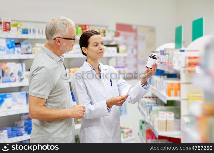 medicine, pharmaceutics, health care and people concept - happy pharmacist and senior man customer with drug and prescription at drugstore