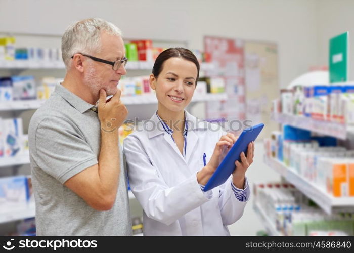 medicine, pharmaceutics, health care and people concept - happy pharmacist with tablet pc computer and senior man customer at drugstore