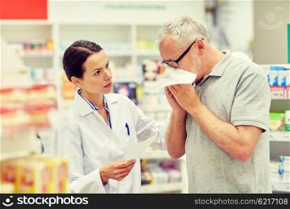 medicine, pharmaceutics, health care and people concept - pharmacist and sick senior man with flu blowing nose at pharmacy