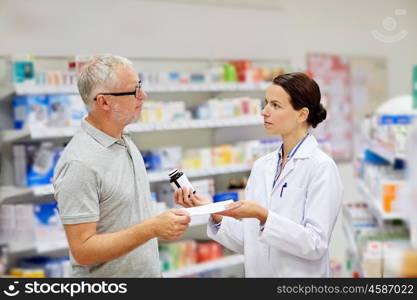 medicine, pharmaceutics, health care and people concept - pharmacist giving drug to senior man customer and taking prescription at drugstore