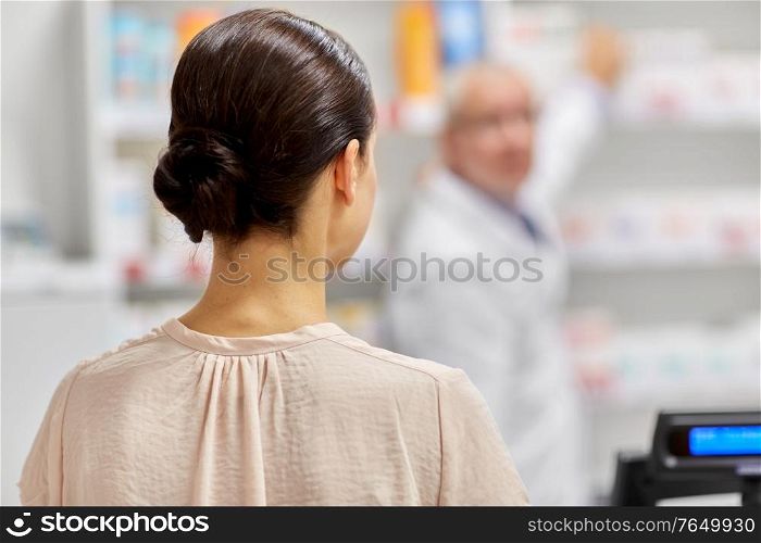 medicine, pharmaceutics, health care and people concept - woman buying drug at pharmacy. woman buying medicine at pharmacy