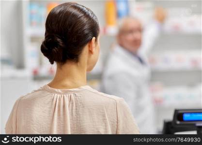 medicine, pharmaceutics, health care and people concept - woman buying drug at pharmacy. woman buying medicine at pharmacy