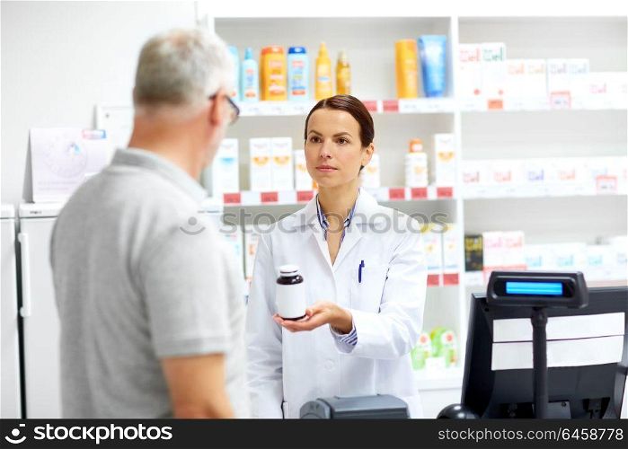 medicine, pharmaceutics, healthcare and people concept - apothecary and senior male customer buying drug at drugstore. apothecary and senior customer at pharmacy