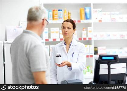 medicine, pharmaceutics, healthcare and people concept - apothecary and senior male customer buying drug at drugstore. apothecary and senior customer at pharmacy