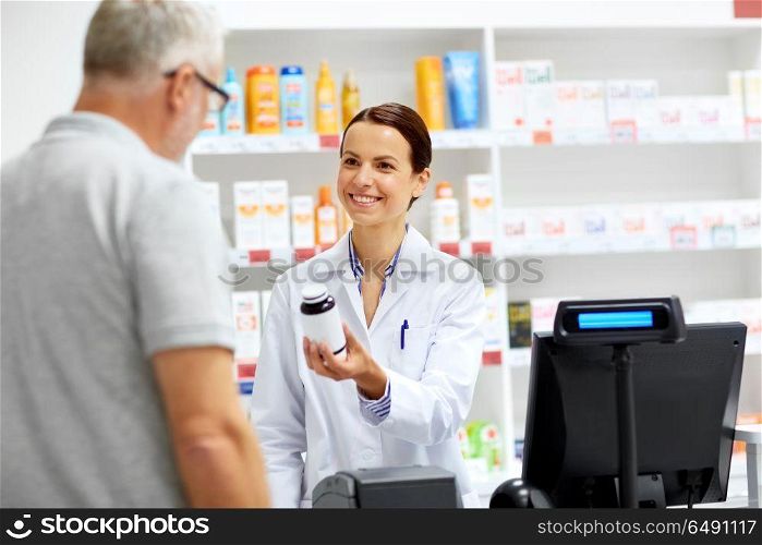medicine, pharmaceutics, healthcare and people concept - apothecary and senior male customer buying drug at drugstore. apothecary and senior customer at pharmacy. apothecary and senior customer at pharmacy