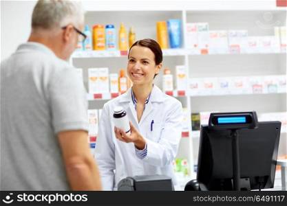 medicine, pharmaceutics, healthcare and people concept - apothecary and senior male customer buying drug at drugstore. apothecary and senior customer at pharmacy. apothecary and senior customer at pharmacy