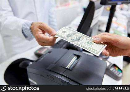 medicine, pharmaceutics, healthcare and people concept - close up of pharmacist taking money from customer at pharmacy. pharmacist taking money from customer at pharmacy