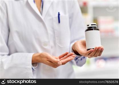 medicine, pharmaceutics, healthcare and people concept - close up of pharmacist with drug at pharmacy. close up of pharmacist with medicine at pharmacy