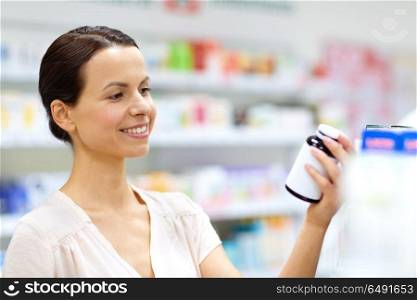 medicine, pharmaceutics, healthcare and people concept - female customer choosing drugs at pharmacy. female customer choosing drugs at pharmacy. female customer choosing drugs at pharmacy