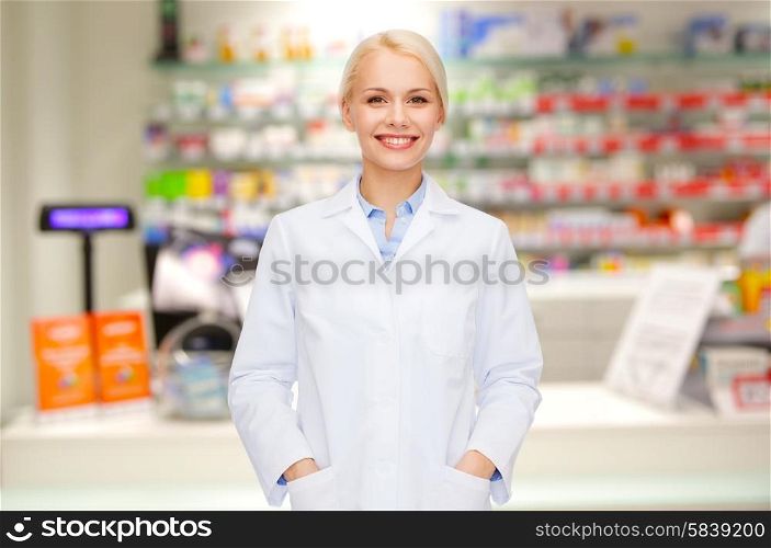 medicine, pharmacy, people, health care and pharmacology concept - happy young woman pharmacist over drugstore background
