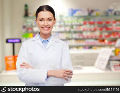 medicine, pharmacy, people, health care and pharmacology concept - happy young woman pharmacist over drugstore background