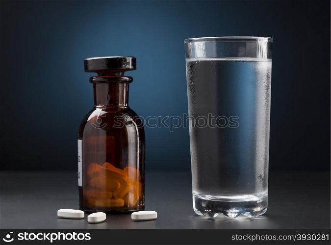 Medicine pills bottle and glass of water. Medicine pills bottle and glass of drink water