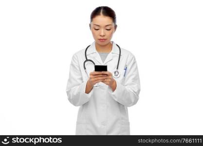 medicine, profession and healthcare concept - asian female doctor or nurse in blue uniform with stethoscope using smartphone over white background. asian female doctor or nurse with smartphone