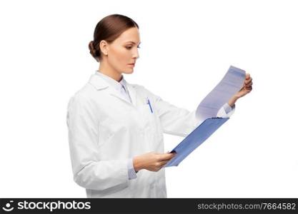 medicine, profession and healthcare concept - female doctor in white coat with clipboard reading medical report. female doctor with clipboard and medical report