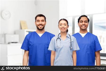medicine, profession and healthcare concept - group of happy smiling doctors or nurses with stethoscope over medical office at hospital on background. group of happy doctors or nurses at hospital