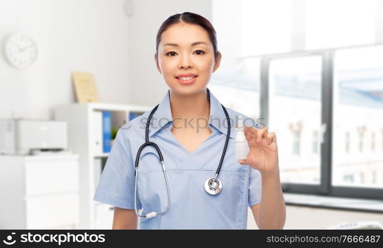 medicine, profession and healthcare concept - happy smiling asian female doctor or nurse in blue uniform with stethoscope and nasal spray over hospital background. smiling asian female doctor or nurse with medicine