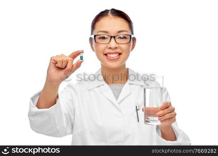 medicine, profession and healthcare concept - happy smiling asian female doctor or nurse pill and glass of water over white background. asian doctor with medicine and glass of water
