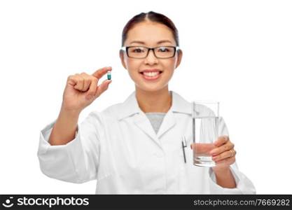 medicine, profession and healthcare concept - happy smiling asian female doctor or nurse pill and glass of water over white background. asian doctor with medicine and glass of water
