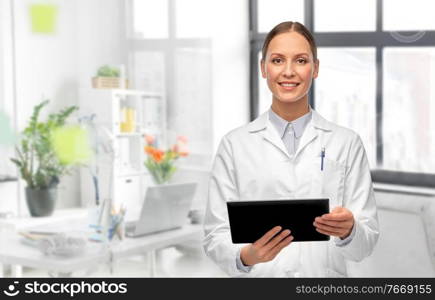 medicine, profession and healthcare concept - happy smiling female doctor in white coat with tablet pc computer over medical office at hospital on background. female doctor with tablet computer at hospital