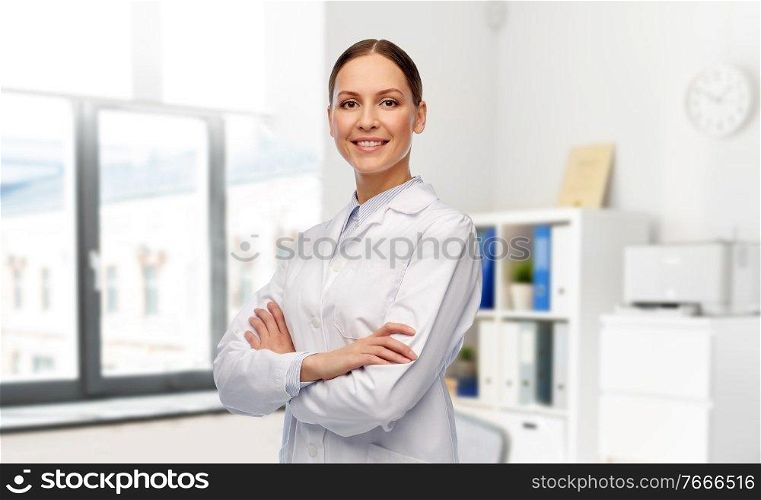 medicine, profession and healthcare concept - happy smiling female doctor in white coat over hospital background. smiling female doctor in white coat at hospital