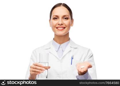 medicine, profession and healthcare concept - happy smiling female doctor with pill and glass of water over white background. female doctor with medicine and glass of water