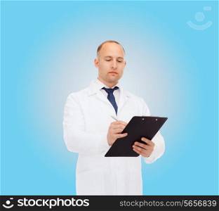 medicine, profession and healthcare concept - serious male doctor with clipboard writing prescription over blue background