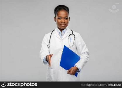 medicine, profession and healthcare concept - smiling african american female doctor or scientist in white coat with clipboard over grey background. happy african american female doctor or scientist
