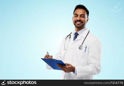 medicine, profession and healthcare concept - smiling indian male doctor in white coat with stethoscope and clipboard over blue background. indian male doctor with clipboard and stethoscope