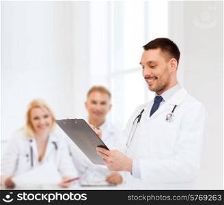 medicine, profession, and healthcare concept - smiling male doctor with clipboard and stethoscope writing prescription over white background