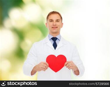 medicine, profession, charity and healthcare concept - smiling male doctor with red heart over natural background
